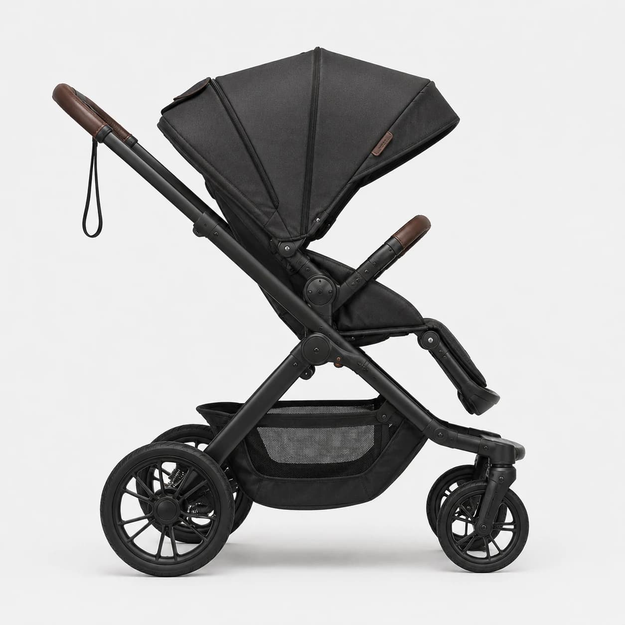 Side view of a black baby stroller showing its frame, canopy, wheels, and storage basket